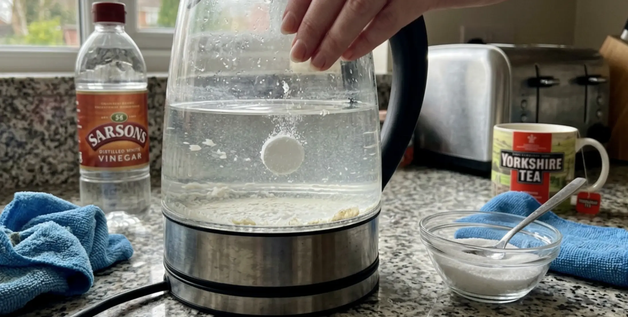 Close-up of a glass kettle with visible limescale deposits on the heating element